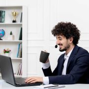 compressed_customer-service-handsome-curly-man-office-suit-with-computer-headset-drinking-coffee